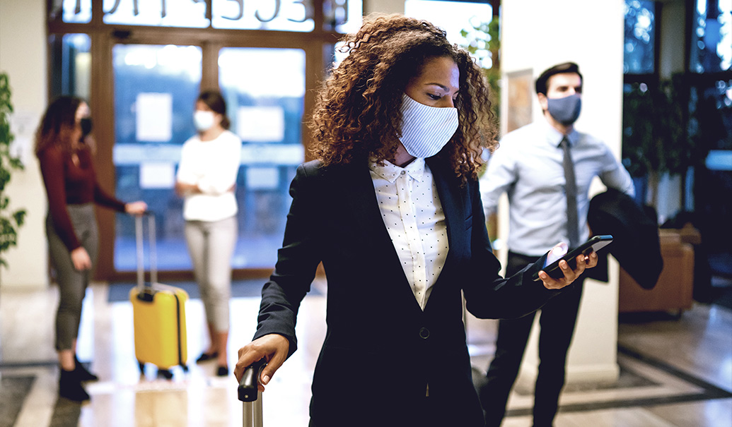 Hotel guests wearing protective face mask and social distance during covid19